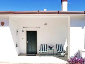 two chairs and a door on a white house at Casa Tonino in Pisticci