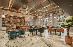 a restaurant with tables and chairs in a room at Lotusa Batulicin by Swiss-Belhotel in Mantaak