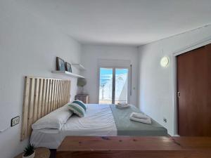 a bedroom with a large bed and a window at Apartaments Aeroclub in Empuriabrava