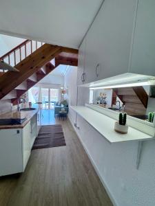 una cocina con encimeras blancas y una escalera en una casa en Apartaments Aeroclub, en Empuriabrava
