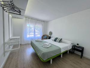 a white bedroom with a bed and a window at Apartaments Aeroclub in Empuriabrava +5 photos