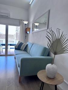 Un sofá azul en una sala de estar con una mesa. en Apartaments Aeroclub, en Empuriabrava
