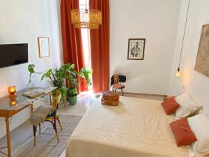 a room with a bed and a table and a desk at Elevada in Castellammare di Stabia