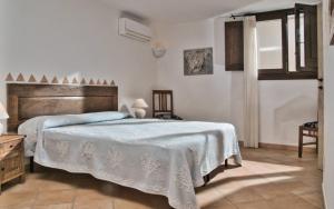 a bedroom with a large bed with a blue blanket at Sea View Grande Pevero 8 in Porto Cervo
