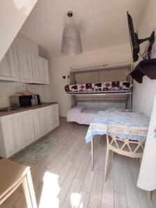 a kitchen with a table and a bed in a room at Appartamenti Renzo&Rita3 Teresina in SantʼAntìoco