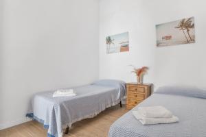 ein Schlafzimmer mit zwei Betten und einer Kommode mit Handtüchern in der Unterkunft Espelete in El Puerto de Santa María