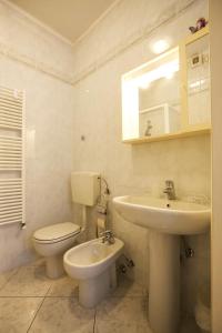 a white bathroom with a toilet and a sink at Piazzale Italia in Oggebbio