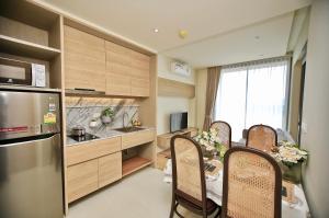 Una cocina con mesa y sillas y un refrigerador. en Rocco Ao Nang by EThan, en Ao Nang Beach