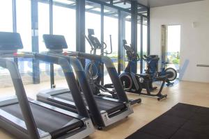 a gym with several treadmills and elliptical machines at Studio Pollux Habibie A1003 City and Sea View in Batam Center