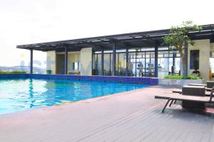 a large swimming pool with a bench and a building at Studio Pollux Habibie A1003 City and Sea View in Batam Center +6 photos