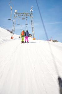 two people on a ski lift in the snow at Ferienwohnung Löwenblick in Thüringerberg
