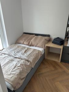 a bed in a room with a nightstand and a bed sidx sidx sidx sidx at Nowa Apartmenty - parking lotniskowy in Palędzie
