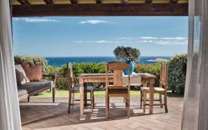a table and chairs with a view of the ocean at Sea View Grande Pevero 8 in Porto Cervo