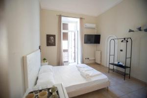 Un dormitorio con una gran cama blanca y una ventana. en San Biagio Suites, en Lecce