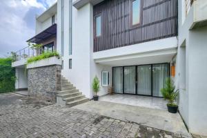 a house with white walls and a brick driveway at Emilia 1 Bedroom Apartment Seminyak by Nagisa Bali in Kerobokan