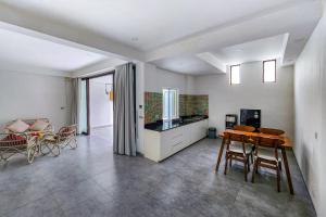 a kitchen and living room with a table and chairs at Emilia 1 Bedroom Apartment Seminyak by Nagisa Bali in Kerobokan