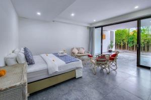 a bedroom with a bed and a table and chairs at Emilia 1 Bedroom Apartment Seminyak by Nagisa Bali in Kerobokan