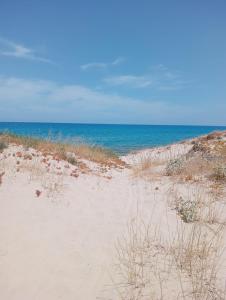 a sandy beach with the ocean in the background at Cozy Rooms in Marina di Sorso +4 photos