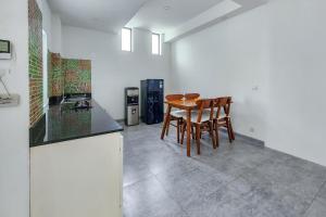 a kitchen with a table and chairs in a room at Emilia 1 Bedroom Apartment Seminyak by Nagisa Bali in Kerobokan