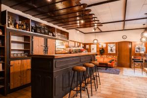 a bar with stools in a room with a couch at Ferienhaus mit Disco, Whirlpool und vielem mehr in Oed
