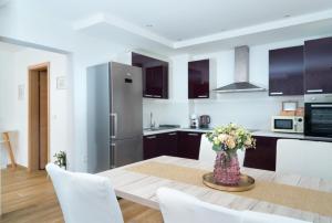 a kitchen with a table with a vase of flowers at New Istrian Experience by Istrian apartments Koper in Koper