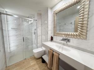 a bathroom with a sink and a shower and a mirror at Akla Burgo de Osma in El Burgo de Osma