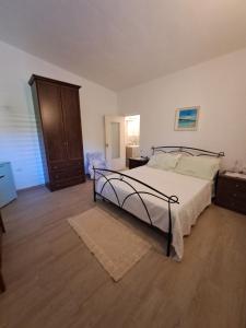 a bedroom with a bed and a wooden floor at B&B li salcuneddi in Aglientu