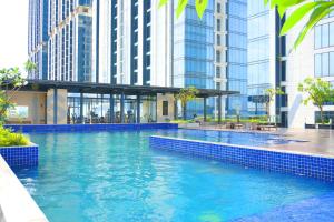 a swimming pool in a city with tall buildings at Studio Pollux Habibie B1617 City View in Batam Center