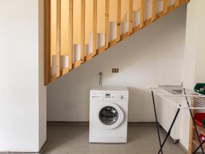 a washing machine in a room with a staircase at Casa Cavina, ampia con giardino e garage in Venas