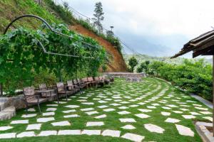 a row of chairs sitting on a grass field at Sapana Mountain Retreat in Sapa +58 photos