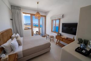 a hotel room with a bed and a television at Divino Caldera in Akrotiri