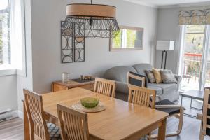 a dining room with a table and a couch at Ski Condo - Mont du Midi 56 in Saint-Philémon