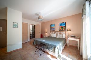 a bedroom with a bed and a table in a room at Hotel Les Ambres in Roussillon