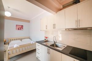 a small kitchen with a bed and a sink at Fjori's Apartments in Sarandë