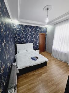a bedroom with a bed with blue floral wallpaper at Aksn new small villa in Gabala