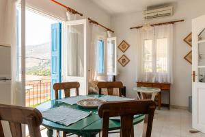 a dining room with a table and chairs and a window at Villa Dimosthenis in Symi