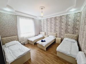 a room with three beds and a window at Aksn new small villa in Gabala