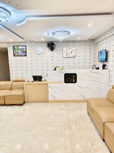 a waiting room with couches and a counter in a building at Hotel Cozzy Inn in Bangalore