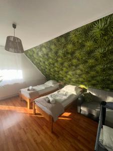 a room with two beds and a green wall at RELAX Apartman in Nyíregyháza