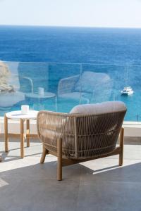a wicker chair and a table and a view of the ocean at The Royal Blue Andros in Batsi