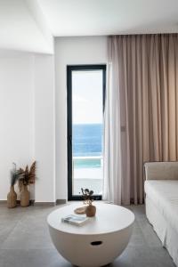 a living room with a white couch and a large window at The Royal Blue Andros in Batsi