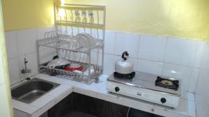 a small kitchen with a sink and a stove at Muka House in Ubud