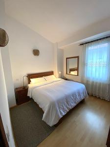 una camera da letto con un letto bianco e una finestra di Relax y conexion - cerca de todo a Santander