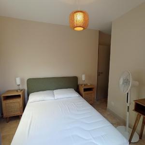 a bedroom with a white bed and a fan at 4ARAP04 - appartement standing vue mer in Collioure
