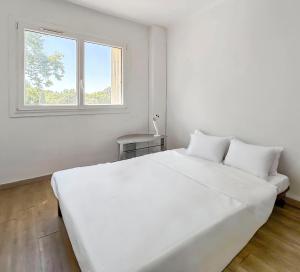 a white bedroom with a large white bed and a window at Balcon Sud, Parking Privé, 4 Chambres Proche Plage in Le Pradet