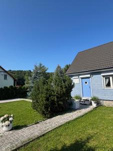 库瑞尼卡慕斯卡Domek Judyty的一座带蓝色门和庭院的房子