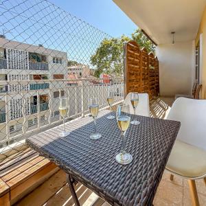 a table with glasses of wine on a balcony at Balcon Sud, Parking Privé, 4 Chambres Proche Plage in Le Pradet