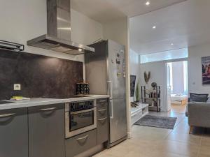 una cucina con elettrodomestici in acciaio inossidabile e un soggiorno di Le Palais - Hypercentre a Grenoble