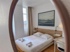 una camera da letto con un letto con due asciugamani sopra di Le Palais - Hypercentre a Grenoble