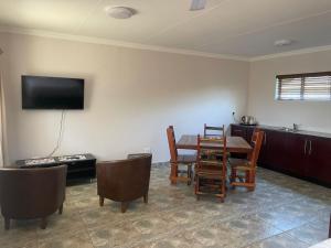 a living room with a table and chairs and a television at Pecan Stay Bed and Breakfast in Rayton
